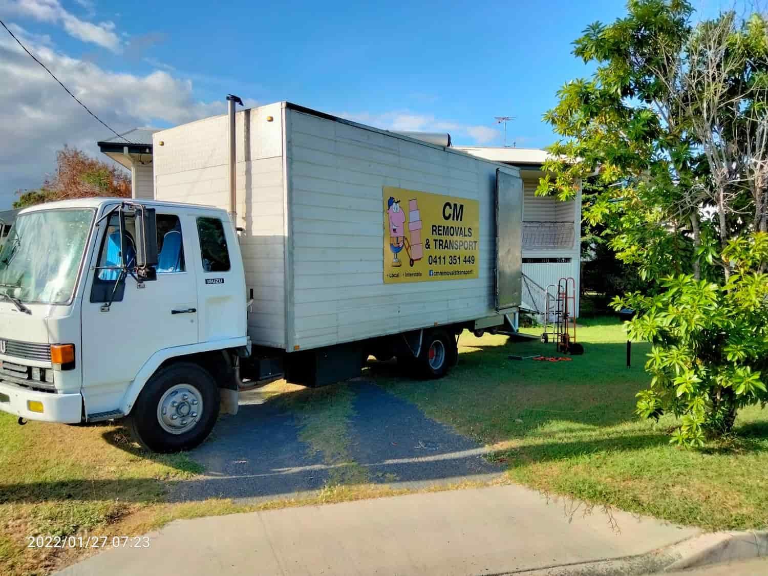 a White Moving Truck is Parked in Front of a House — CM Removals & Transport In Gympie, QLD