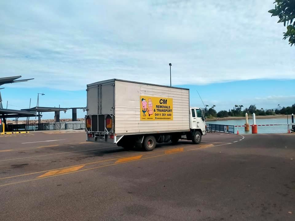 a White Moving Truck is Parked in a Parking Lot Next to a Body of Water — CM Removals & Transport In Sunshine Coast, QLD