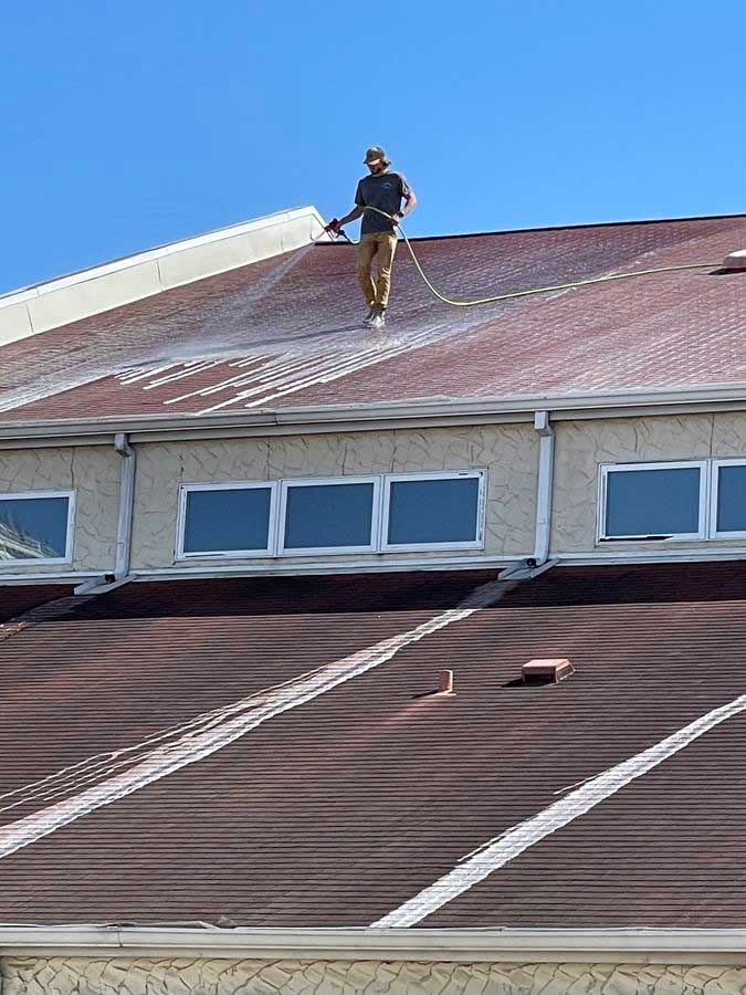 Roof being cleaned with pressure washer
