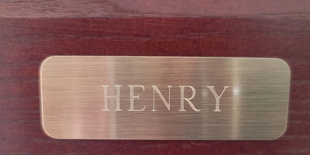 A brass plaque with the name henry engraved on it