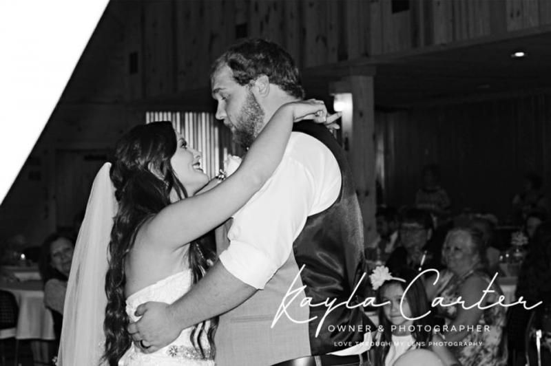 Bride and groom sharing a dance at a wedding reception, in black and white.