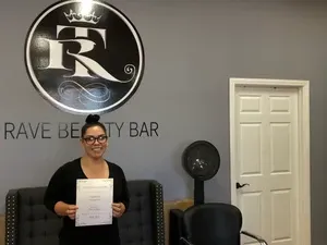 Woman with glasses holding certificate | Sylmar, CA | Rave Beauty Bar