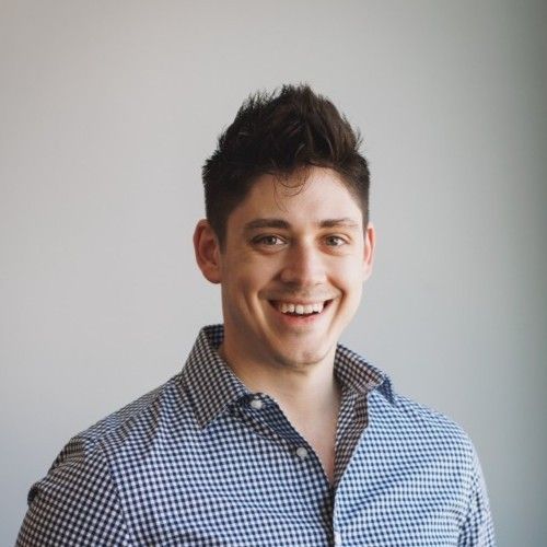 A man in a plaid shirt is smiling for the camera.