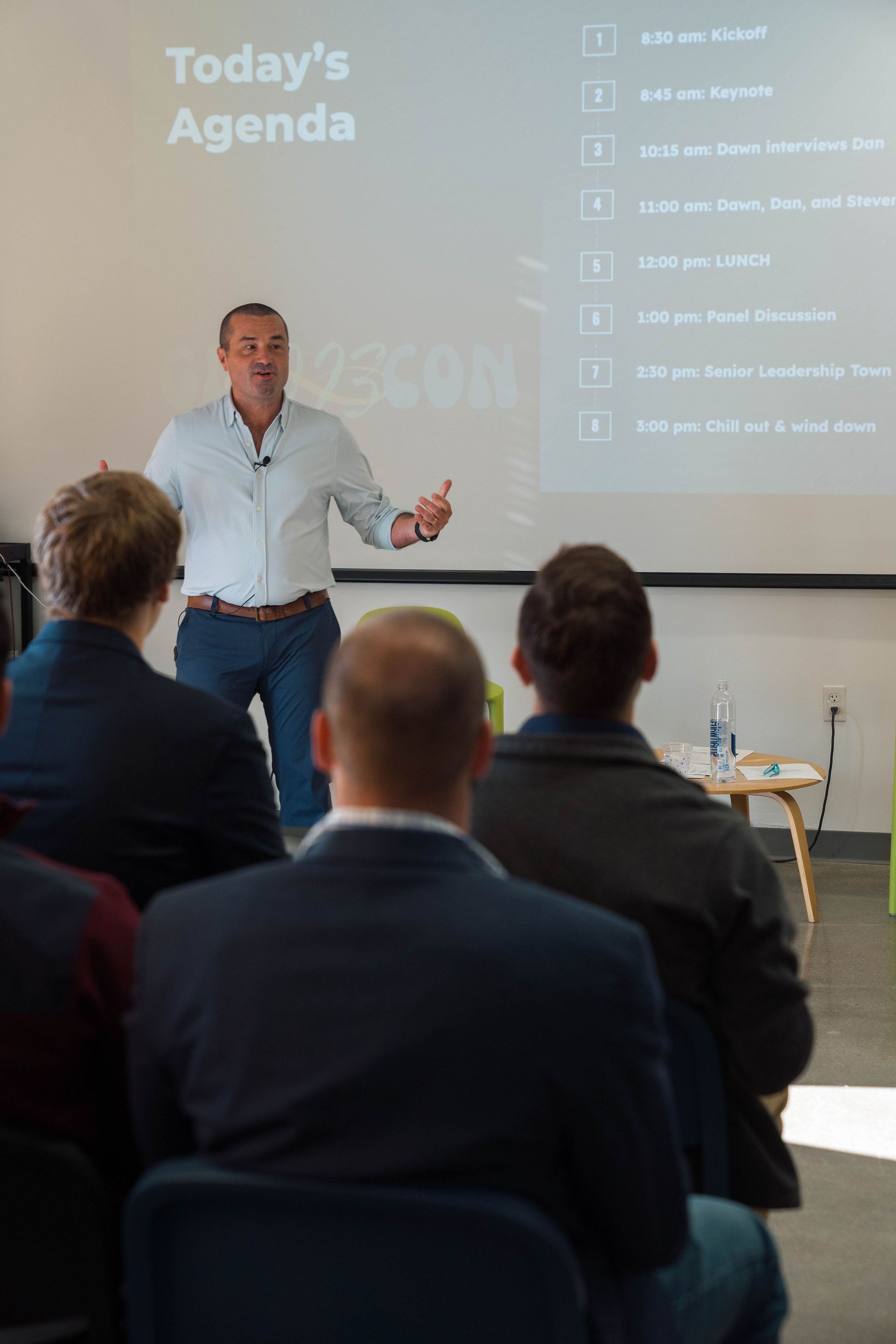 A man is giving a presentation to a group of people sitting in chairs.