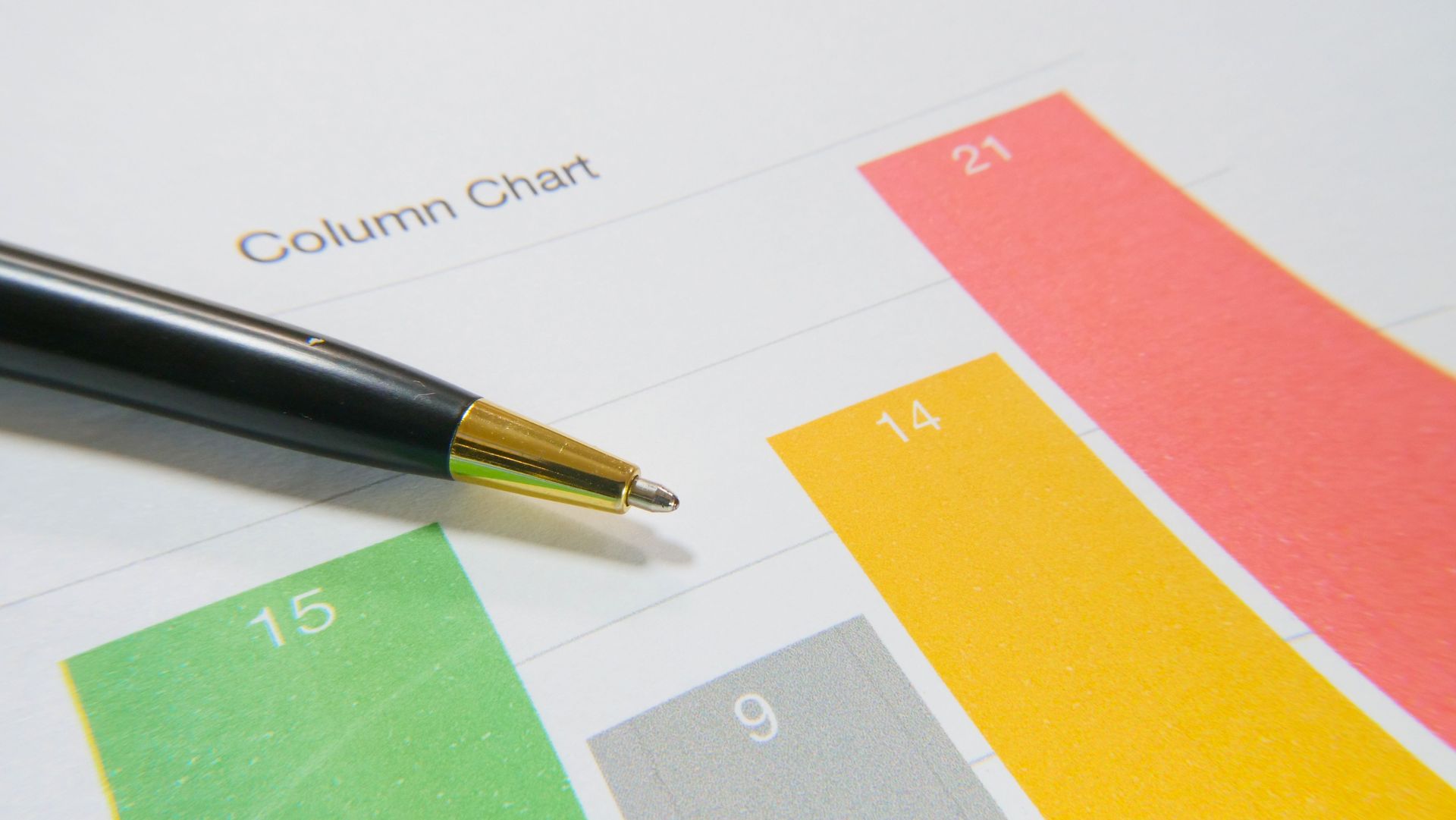Pen pointing at a colorful bar chart with labeled columns.