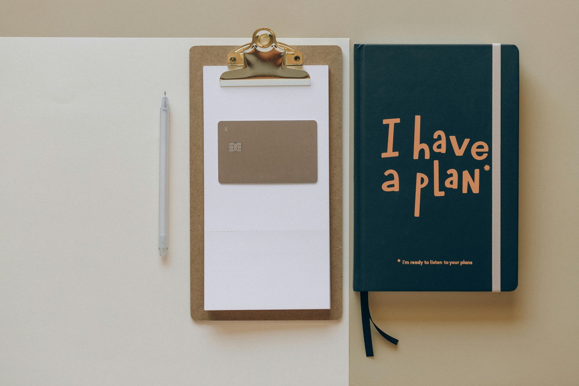 Clipboard with a credit card, notebook that says 