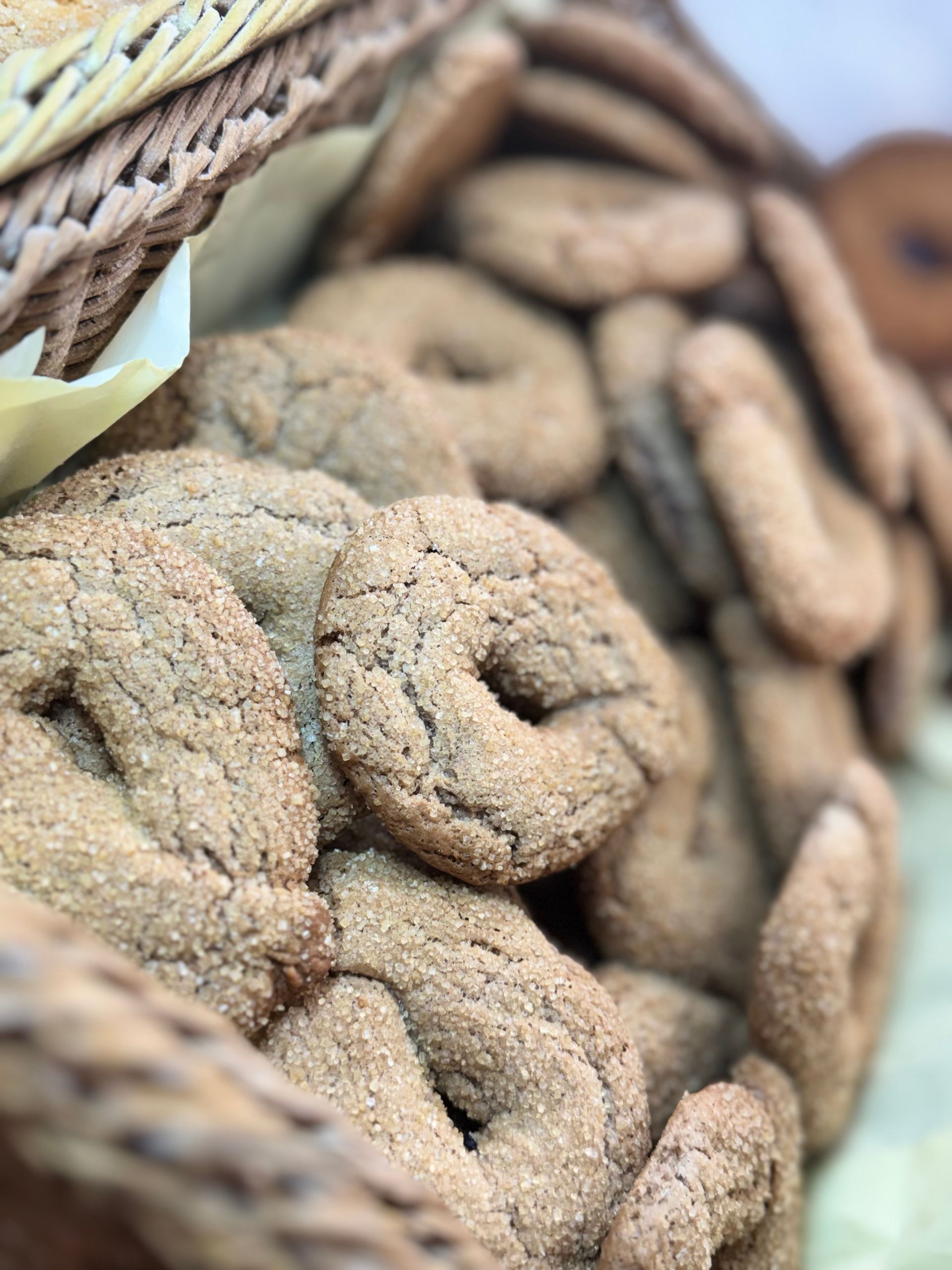 Cesto di biscotti e pasticcini assortiti ricoperti di zucchero a velo, in un cesto di vimini.