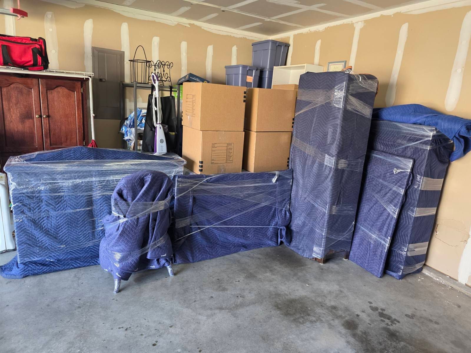 People packing boxes in an office with desks, computer monitors, and shelves.