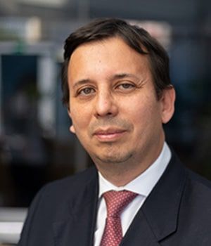 A man in a suit and tie is smiling for the camera.