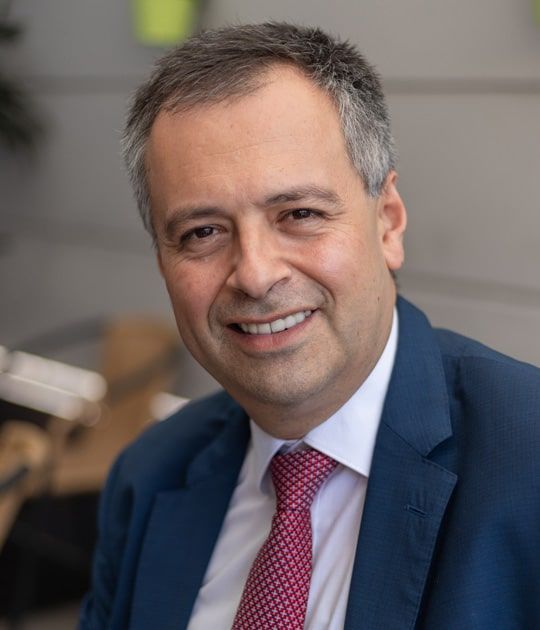 A man in a suit and tie is smiling for the camera.