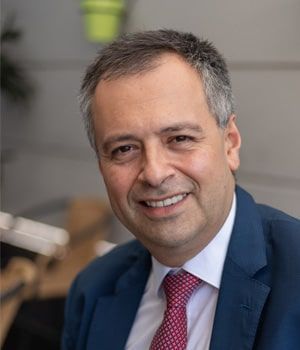 A man in a suit and tie is smiling for the camera.