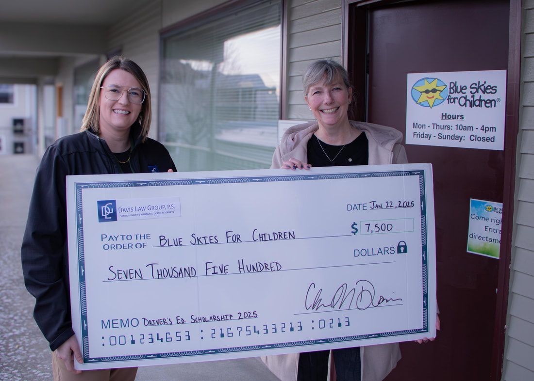 Two women holding oversized check for 