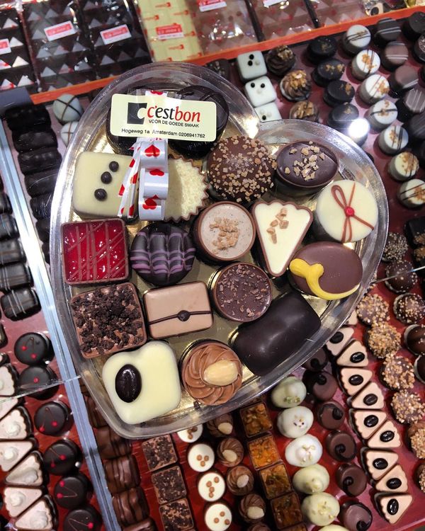 Een hartvormige container gevuld met veel chocolaatjes