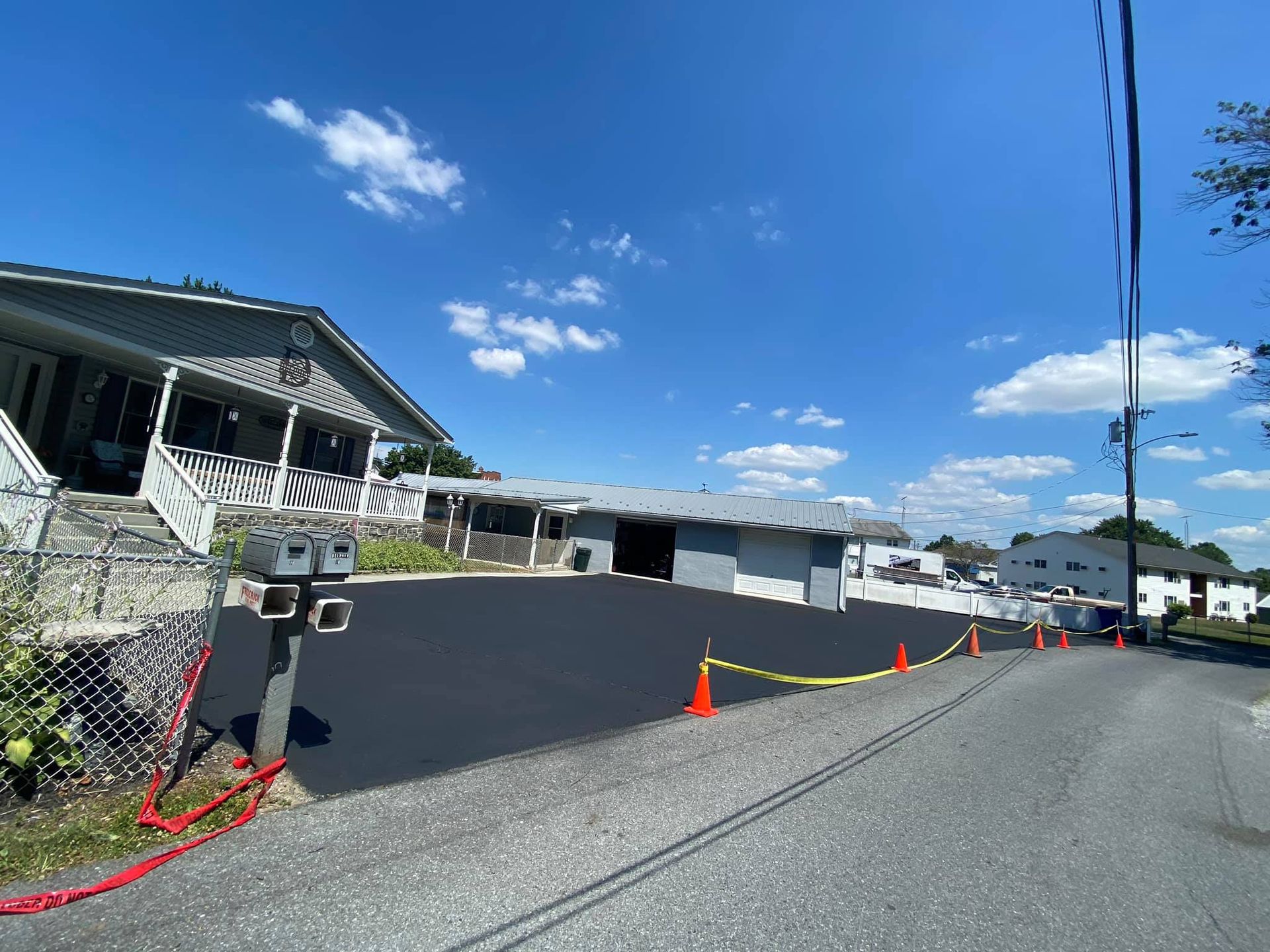 A house is sitting on the side of a road next to a parking lot.