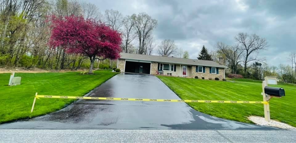 A house with a mailbox in front of it is surrounded by a yellow tape.