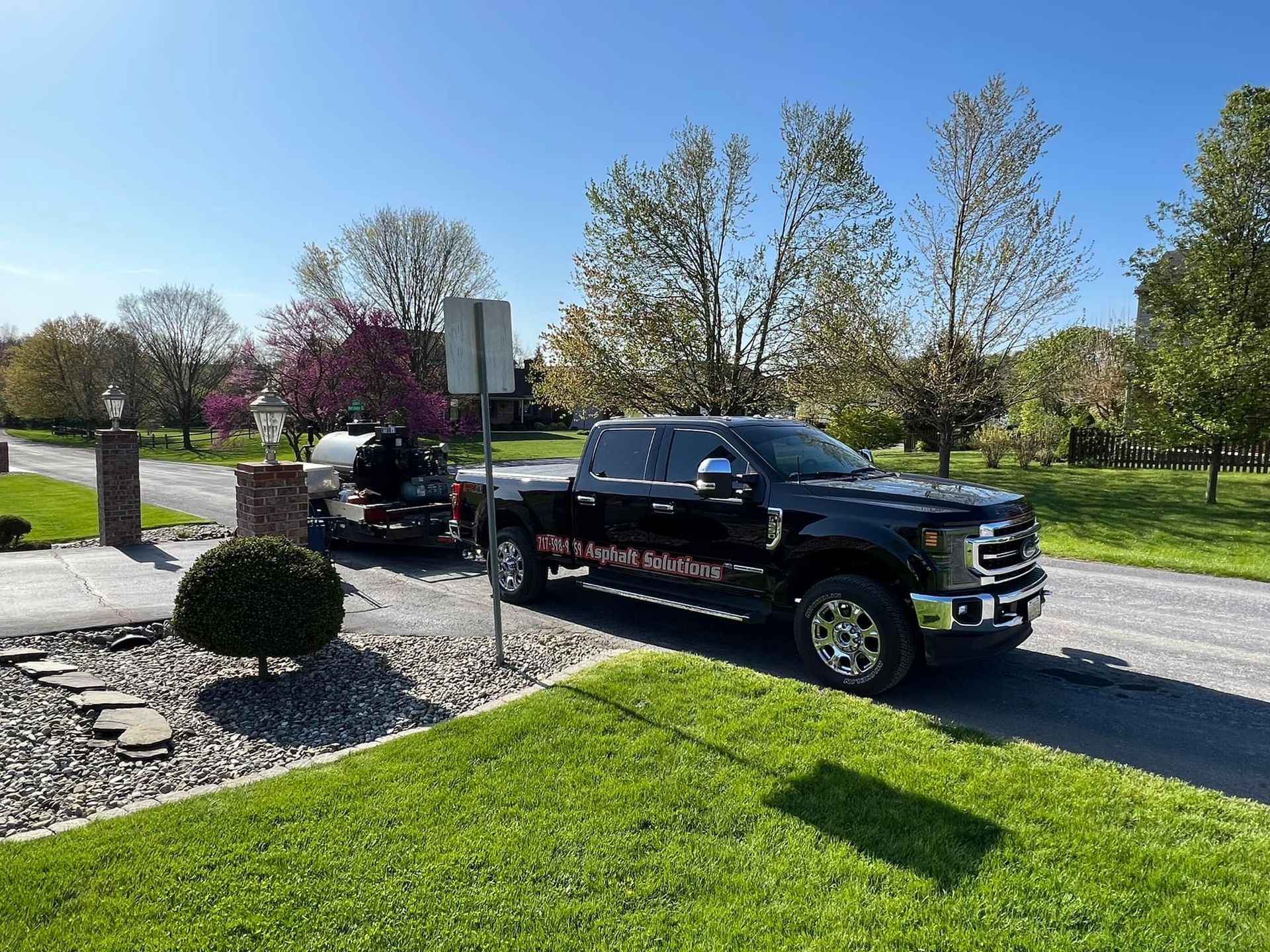 A black truck is parked on the side of the road.