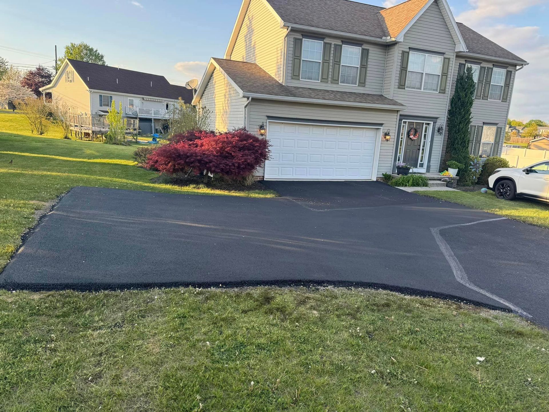 A house with a car parked in front of it and a driveway.