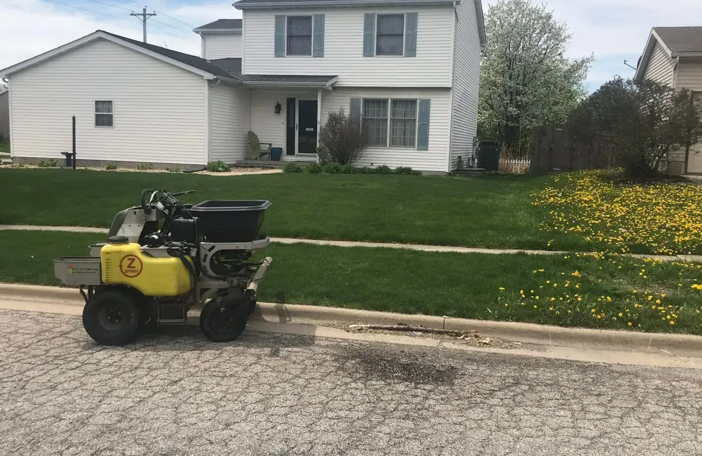 Green John Deere utility vehicle pulling a seeding machine on a grass field.