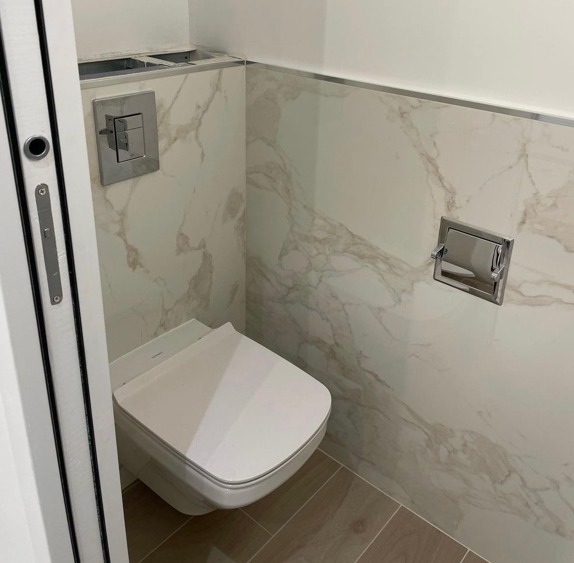 une salle de bain avec toilettes et mur en marbre