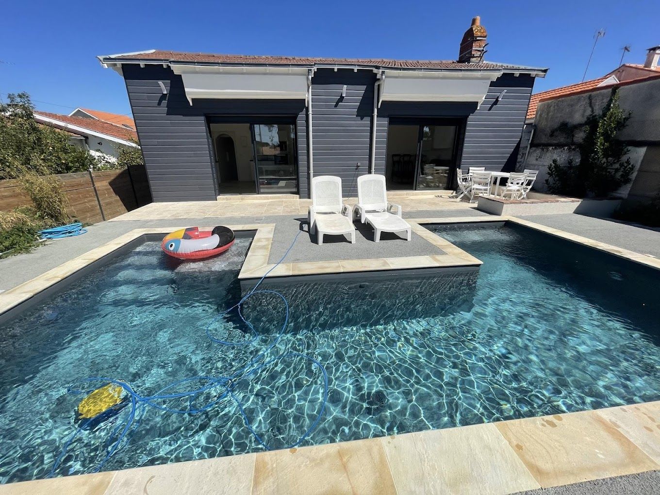 une grande piscine se trouve devant une maison