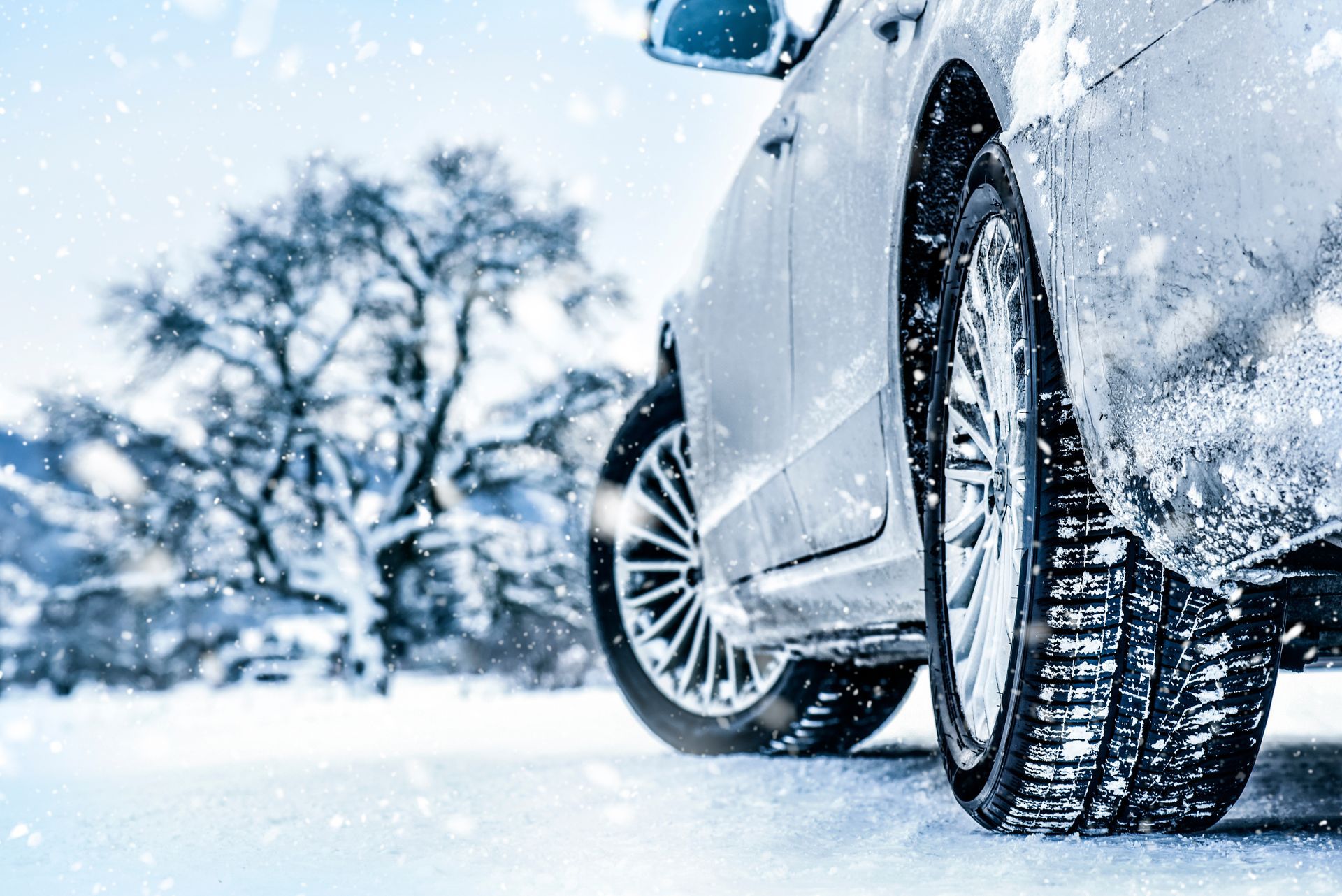 Car with winter tires driving in snowy conditions.