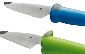 Two child-safe kitchen knives: blue and green handles, silver blades shaped like crocodile heads.