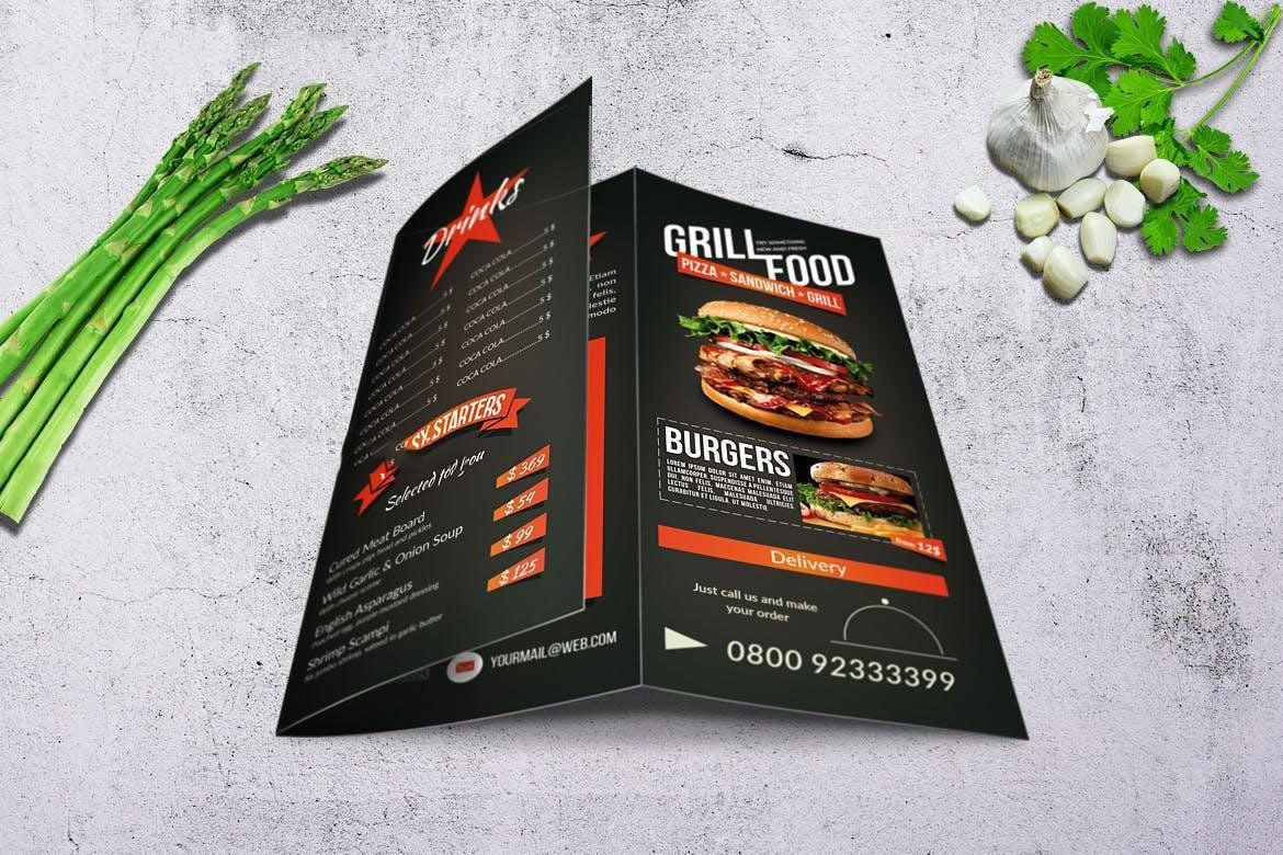 A grill food menu is sitting on a table next to asparagus and garlic.