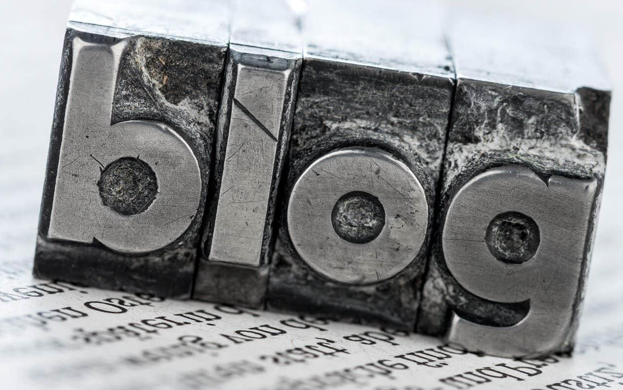 The word blog is written in metal type on a piece of paper.