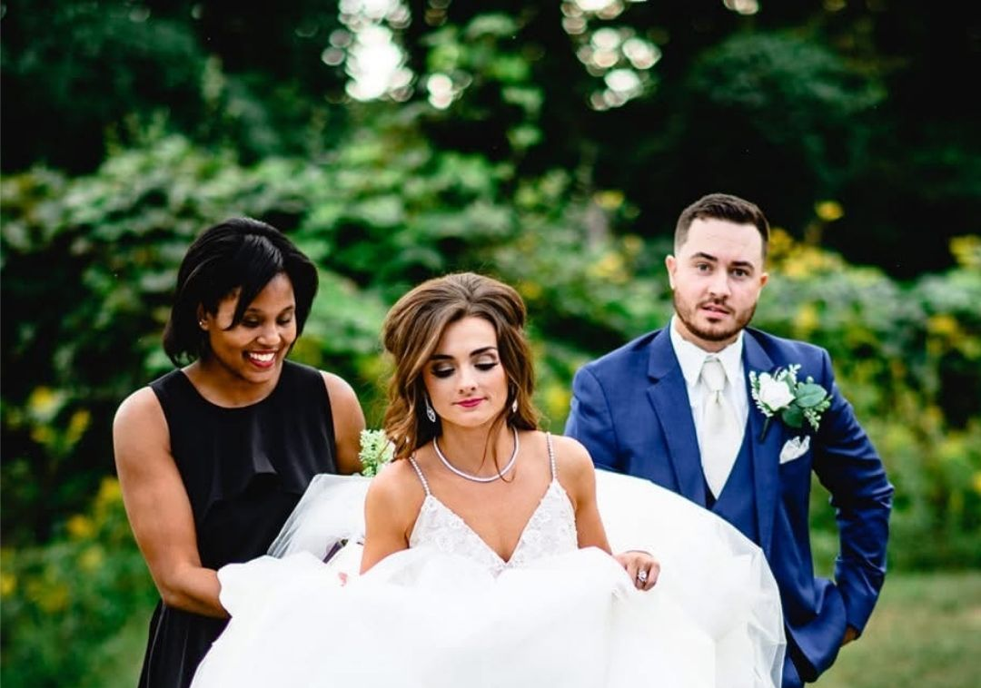 Wedding Planner assisting bride with bridal gown