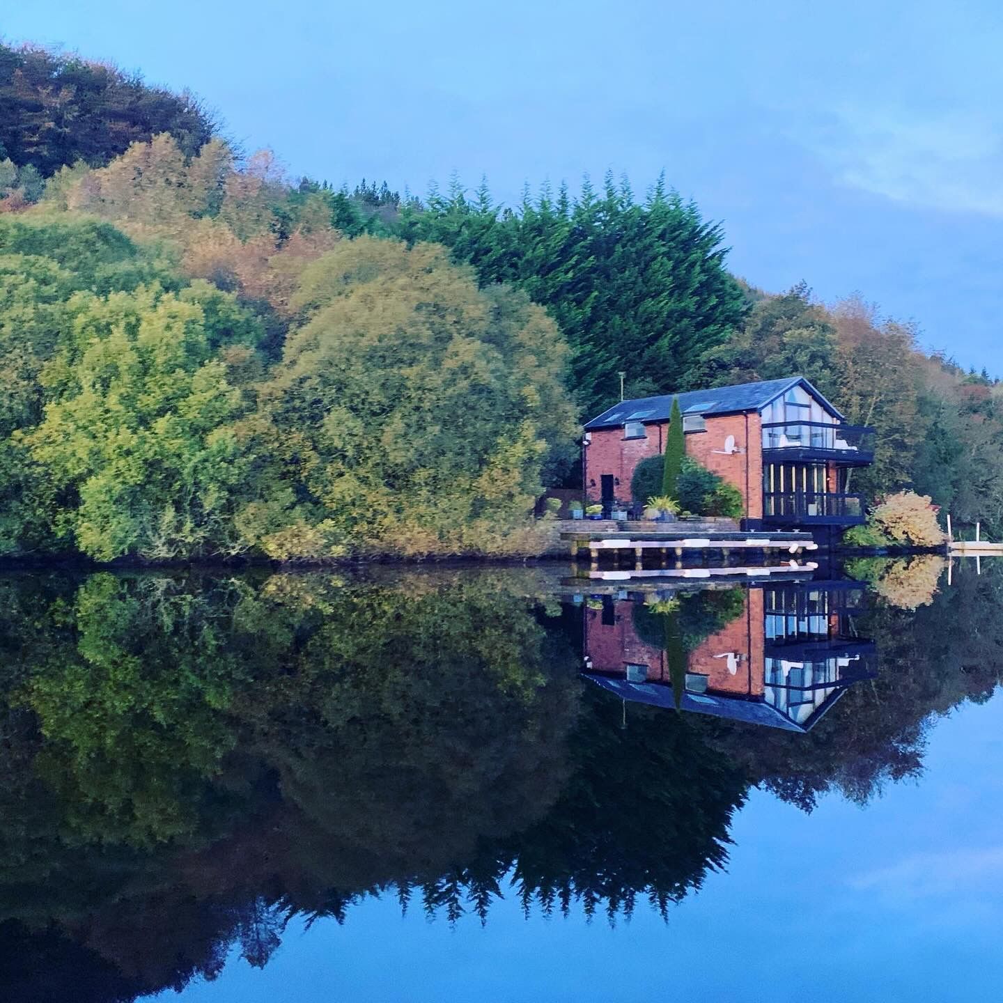 A house sits on a small island in the middle of a lake
