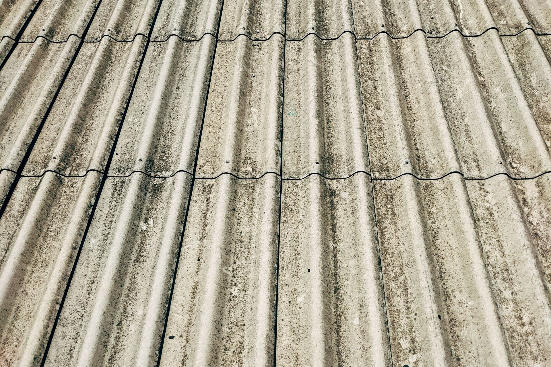 Close-up of weathered corrugated roof panels with dirt and stains