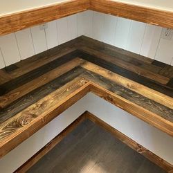 Corner bench with dark wood slats and white paneled walls in a small nook