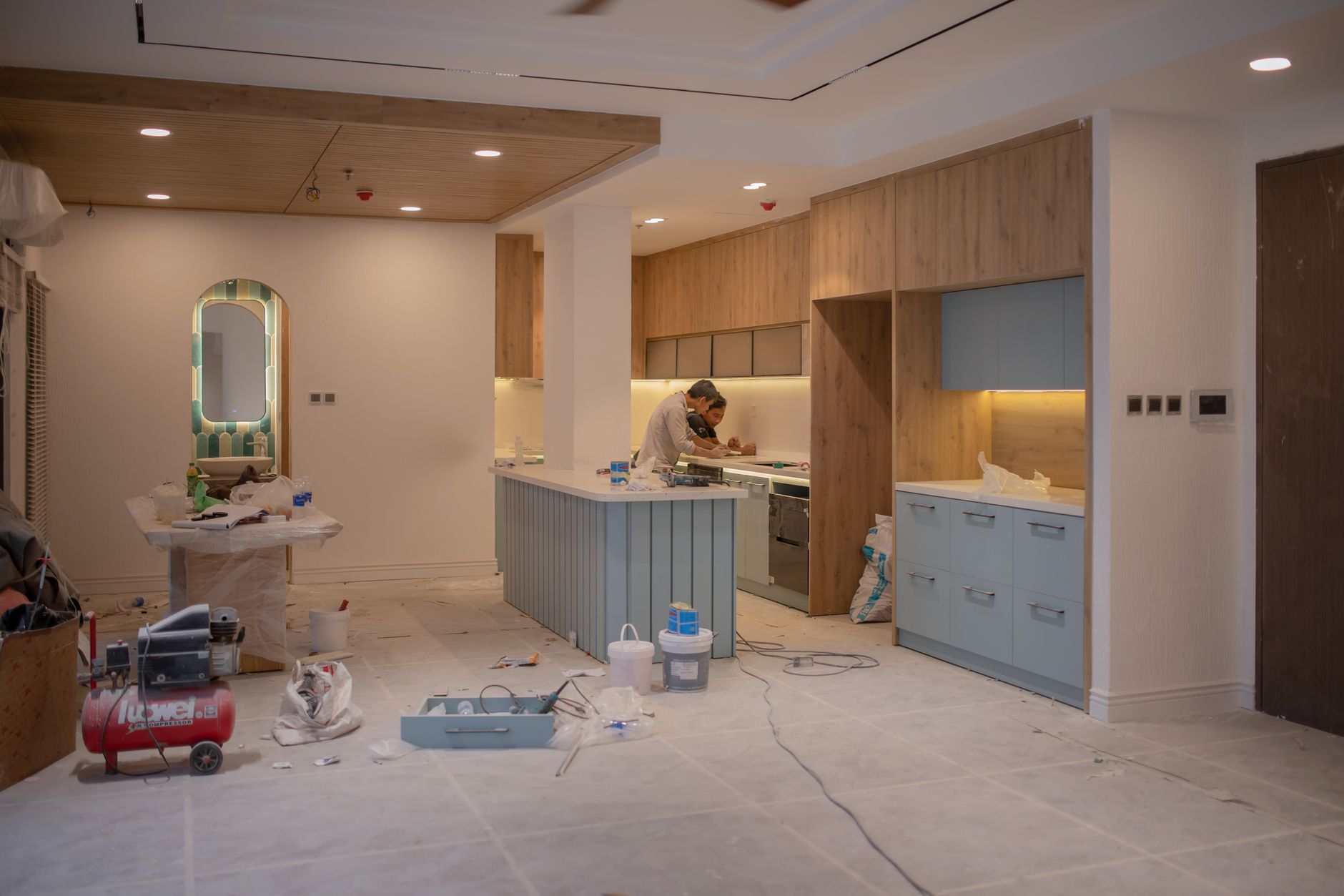Renovation site with a kitchen installation, tools, and materials in a modern apartment interior