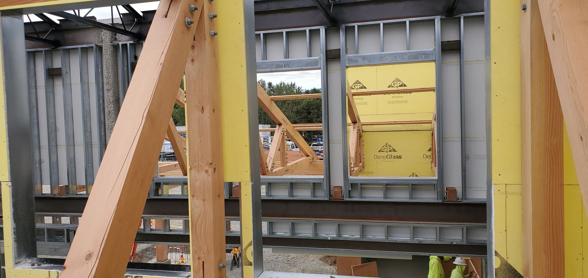 Steel beams framing a yellow shipping container at a construction site