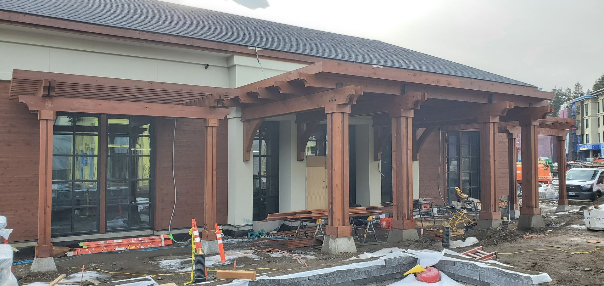 Wooden porch under construction on a house exterior, with exposed beams and scattered building materials.