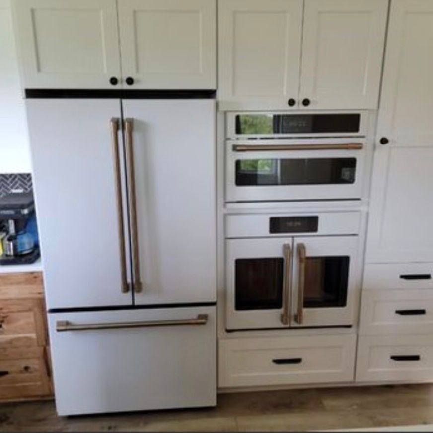 White kitchen with a large refrigerator and built-in double oven cabinetry