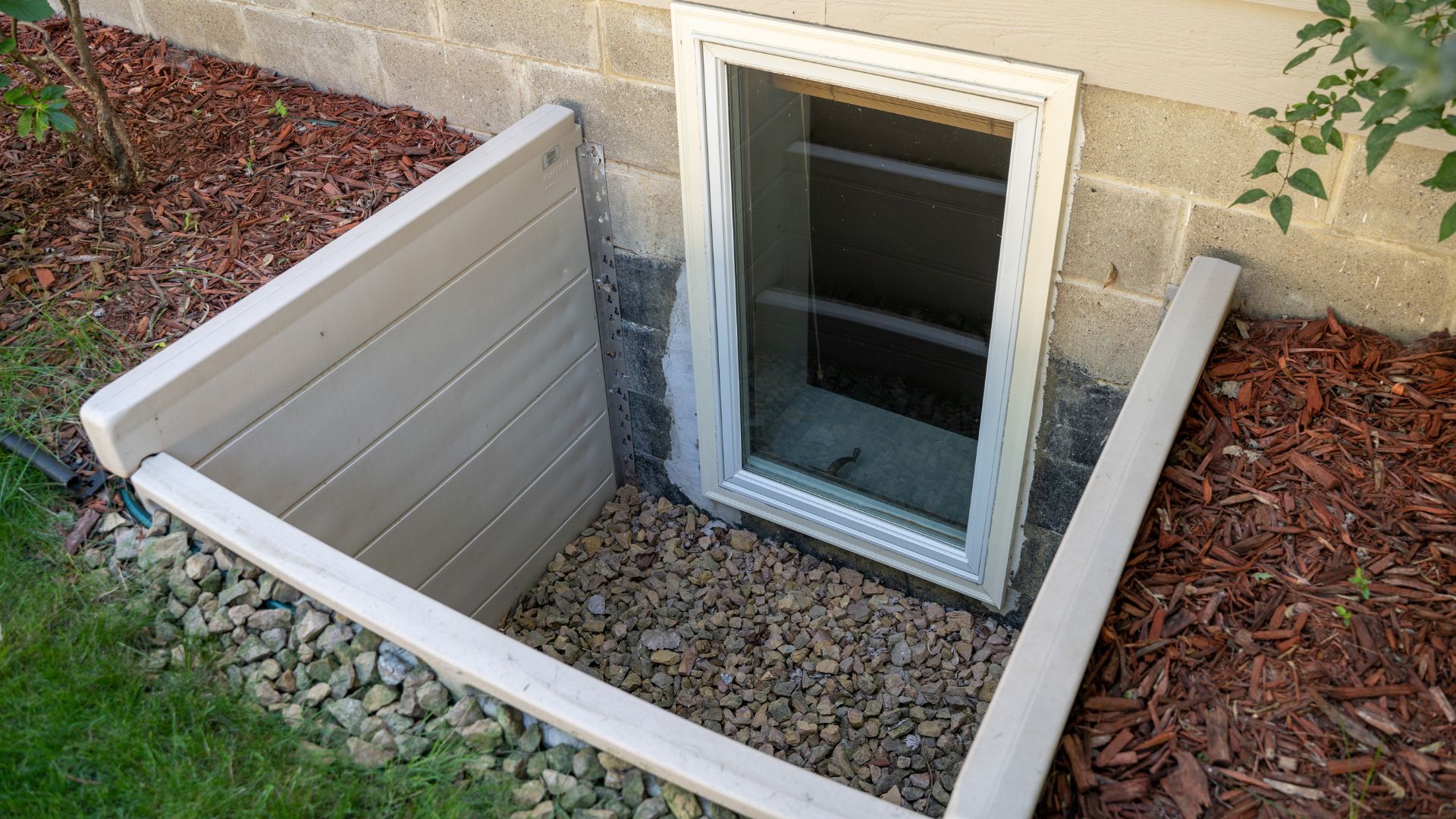 There is a window in the basement of a house.