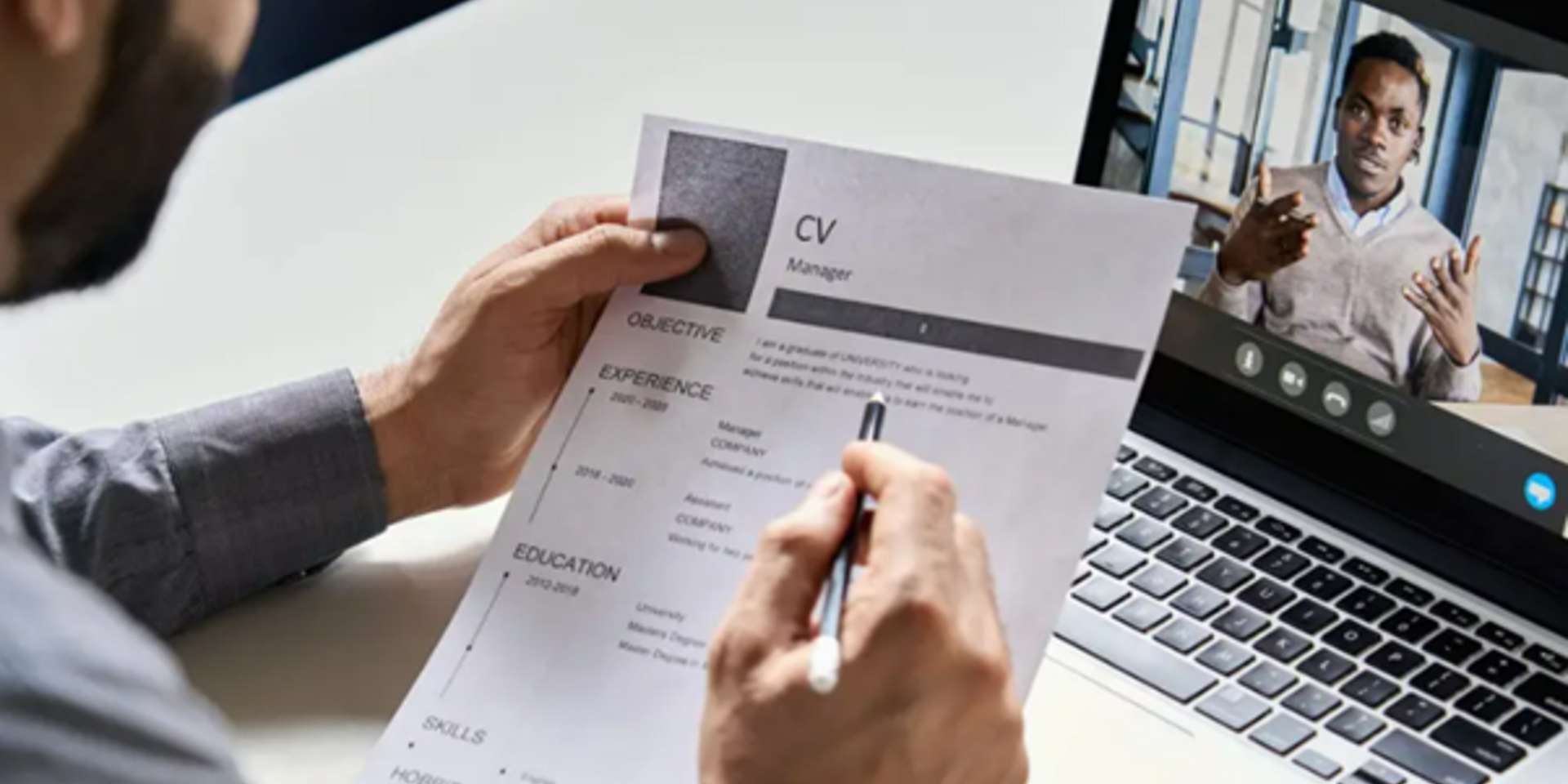 Person reviewing a CV during a video call interview with a potential candidate.