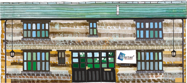 Brick building with green roof, windows and doors. Sign for 