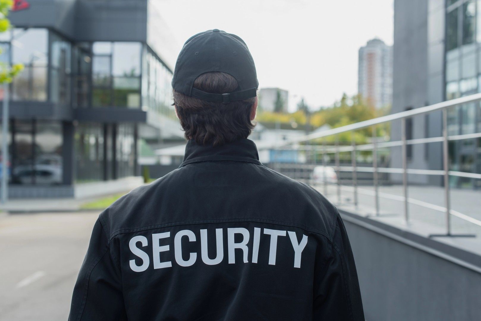 Guardia giurata in uniforme nera con la scritta