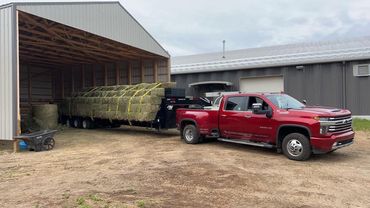 A picture of a red hotshot truck with a trailer in a yard in Grande Prairie