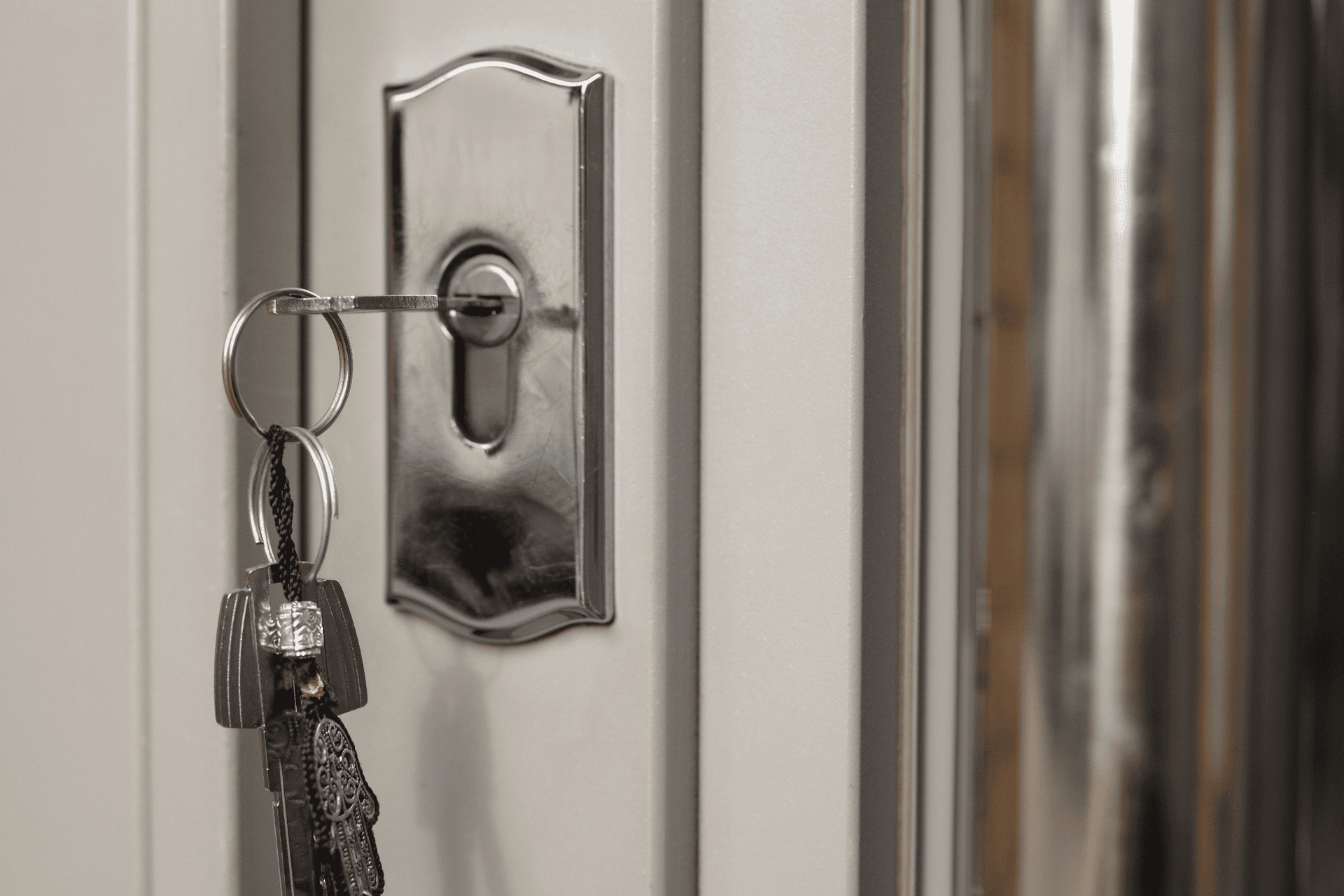 Key hanging in a lock on a white door panel