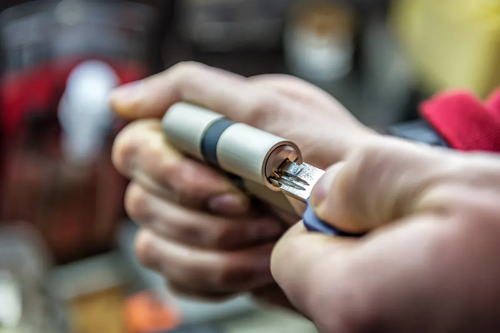 Hands using a lighter to heat a small metal tool, close-up.