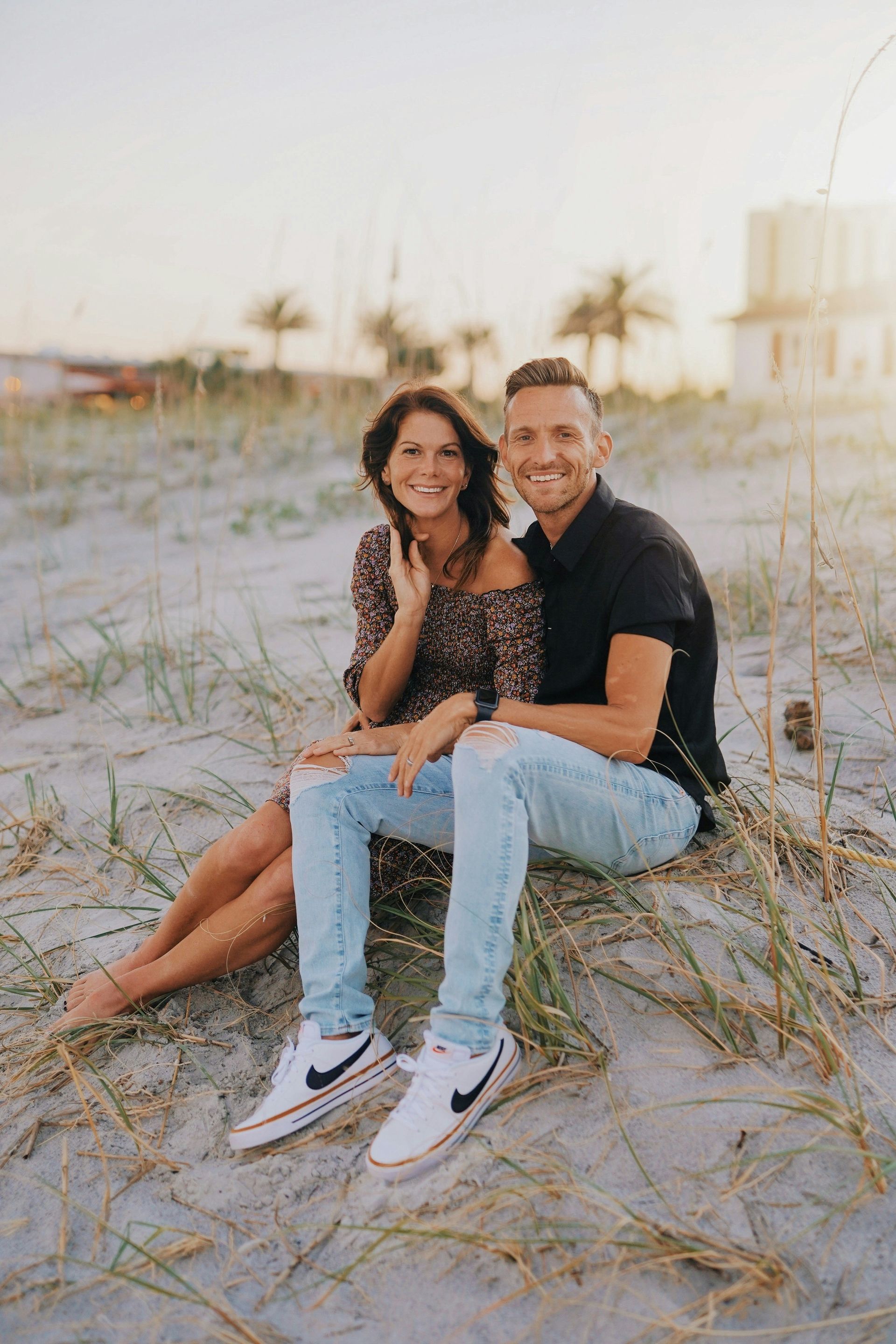 A man and a woman are sitting on the beach.