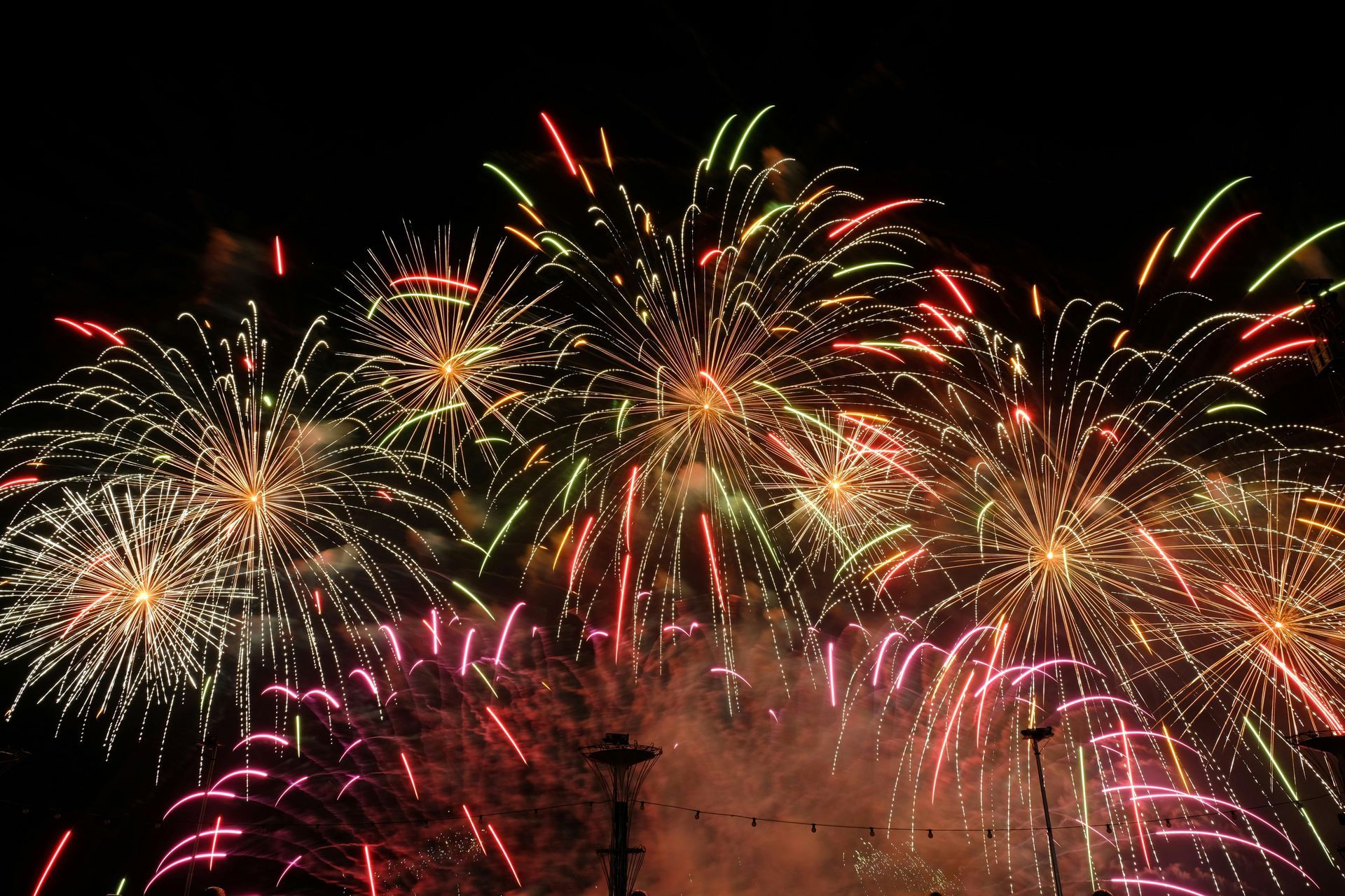 A bunch of fireworks are going off in the night sky