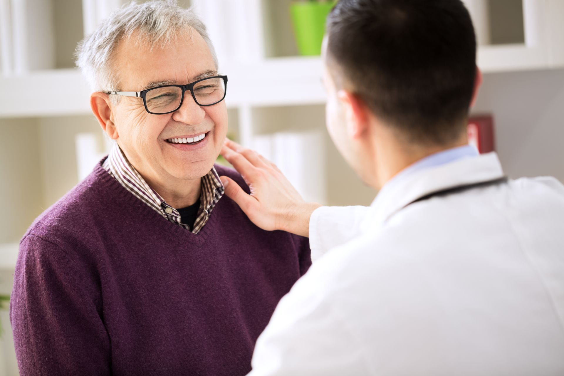 Doctor examining a smiling patient in a clinic