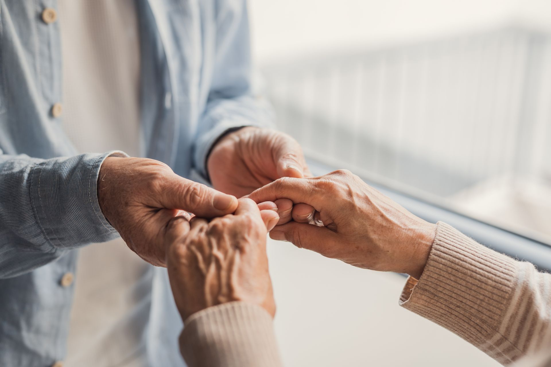 Close-up of an elderly couple holding hands, expressing love, support, and lifelong companionship