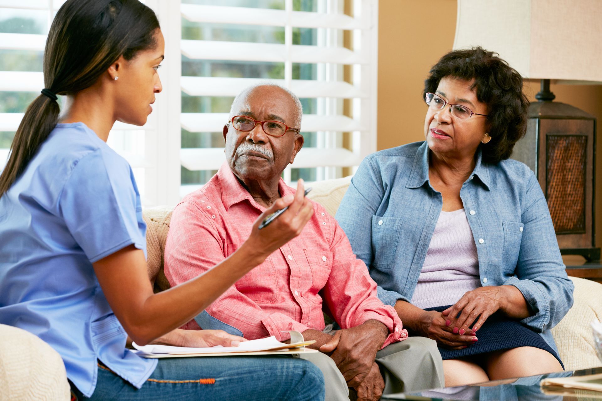 Home healthcare provider consulting patients during an in-home visit.
