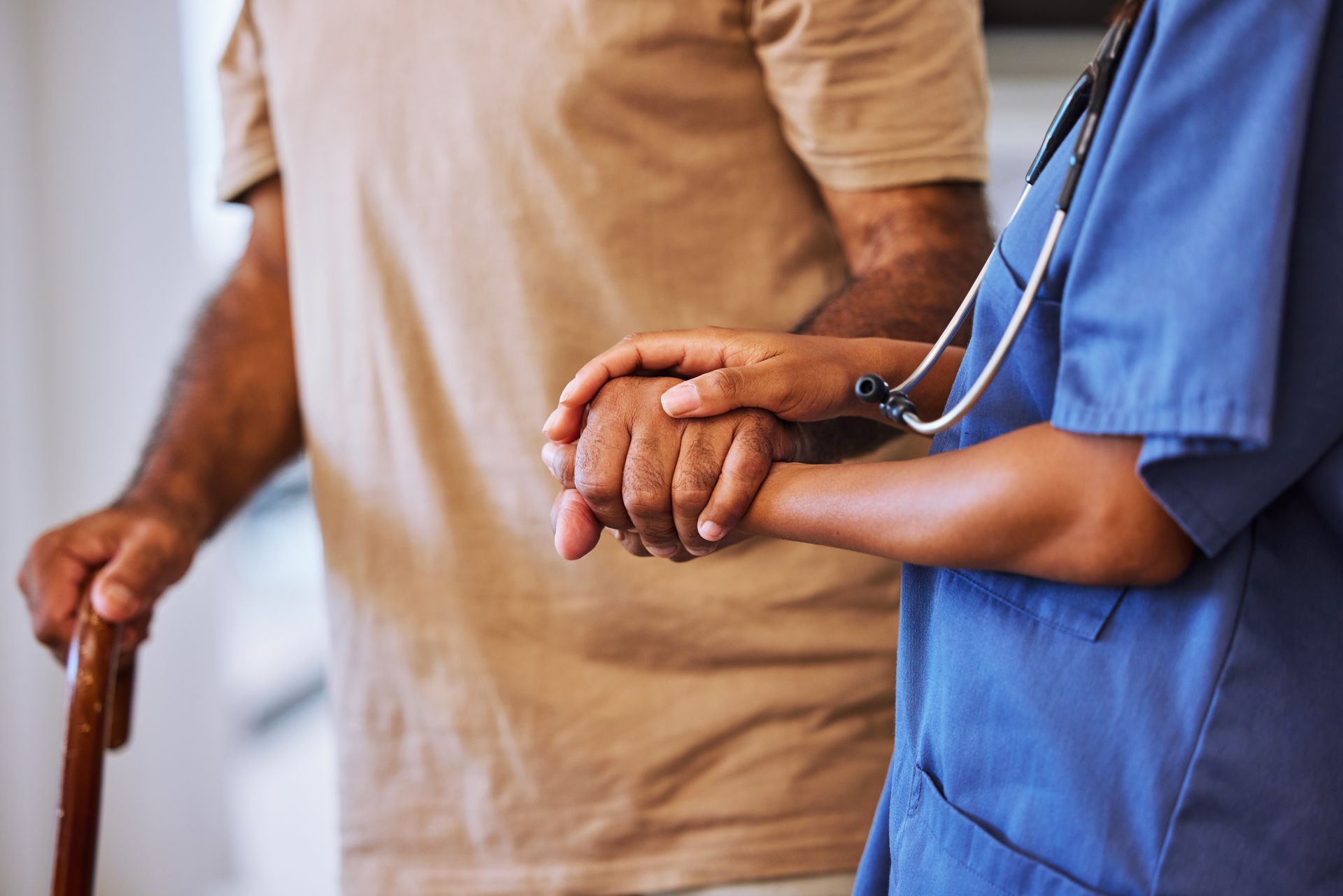 Healthcare worker holding hands with a patient in a hospital setting