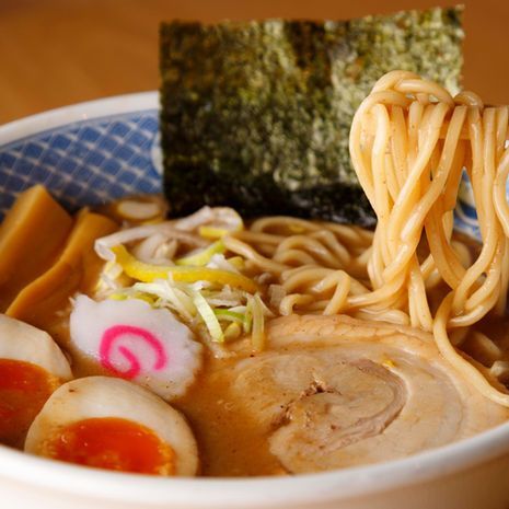 Ramen bowl with noodles, sliced pork, seaweed, egg, and fish cake in broth